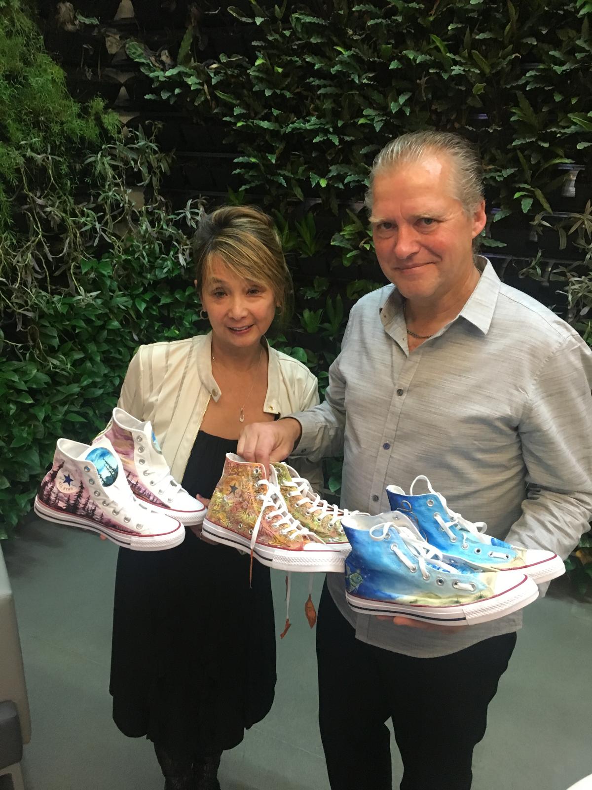 Teresa May holding hand-painted canvas shoes at a Shoe Bank Canada fundraiser in 2019.